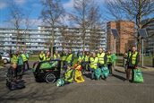De Straatjutters samen op de foto, in hun gele hesjes met groene afvalzakken in de hand.
