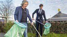 Edwin Ooms (McDonald's) en Vincent Karremans (Gemeente Rotterdam) rapen gezamenlijk afval in de omgeving van een McDonald's-vestiging.