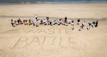 Deelnemers en de tekst die ze in het zand hebben geschreven: Waste Battle